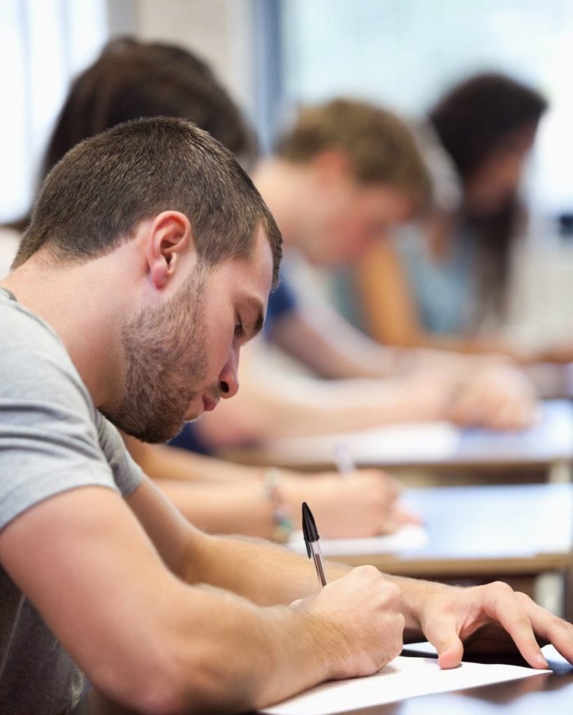 Photo fictive d'élèves conducteurs studieux en cours théorique, auto-école à Genève, préparant l'examen du code de la route pour obtenir le permis de conduire suisse.